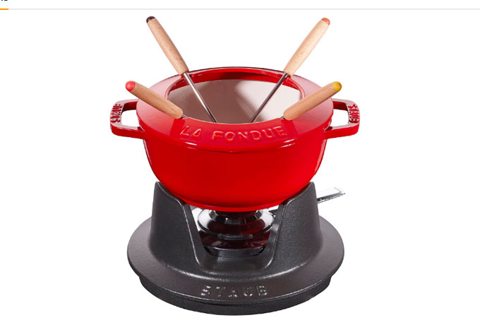 Conjunto de fondue vermelho, com quatro espetos, em fundo branco