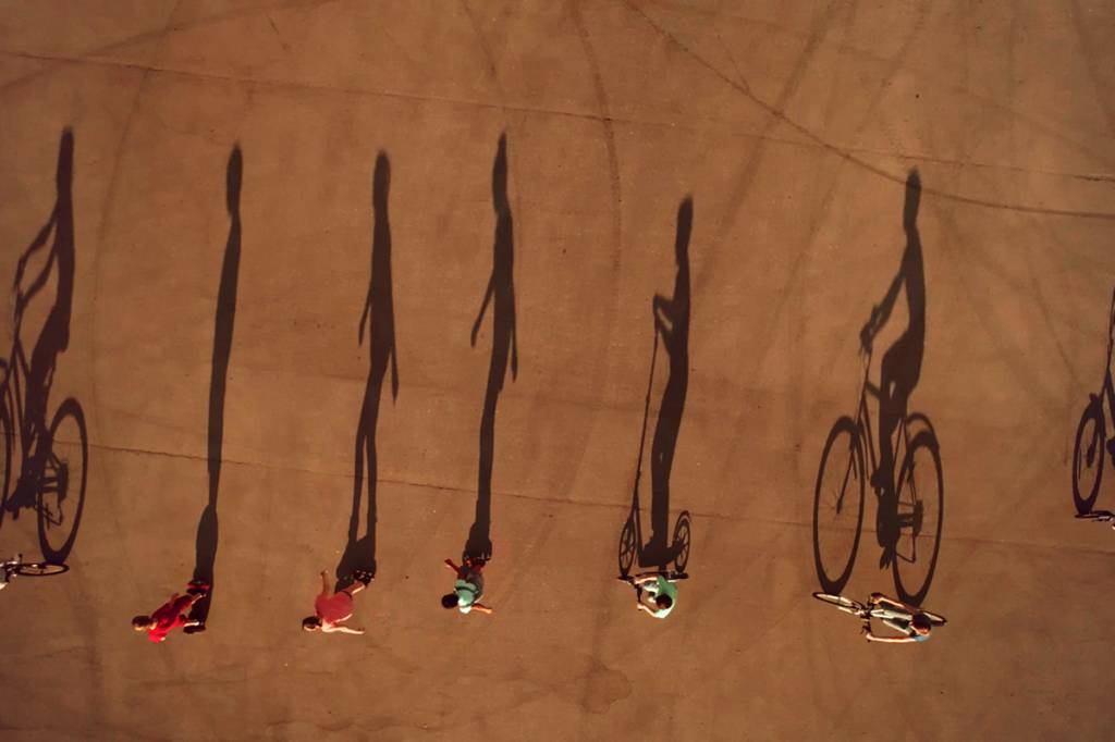 sombra projetada de pessoas andando de patinete, hoaverboard e bicicleta